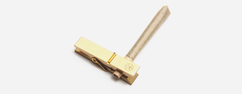 Een gouden wasknijper met een houten handvat.
