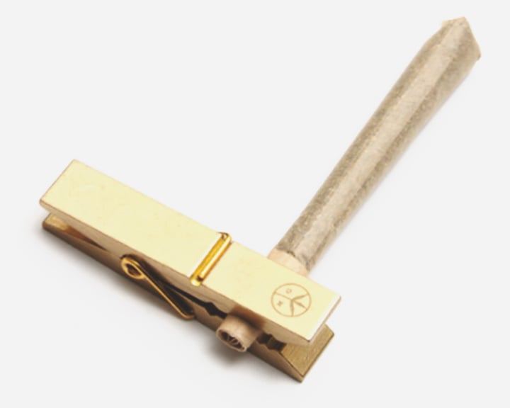 Een gouden wasknijper met een houten handvat.