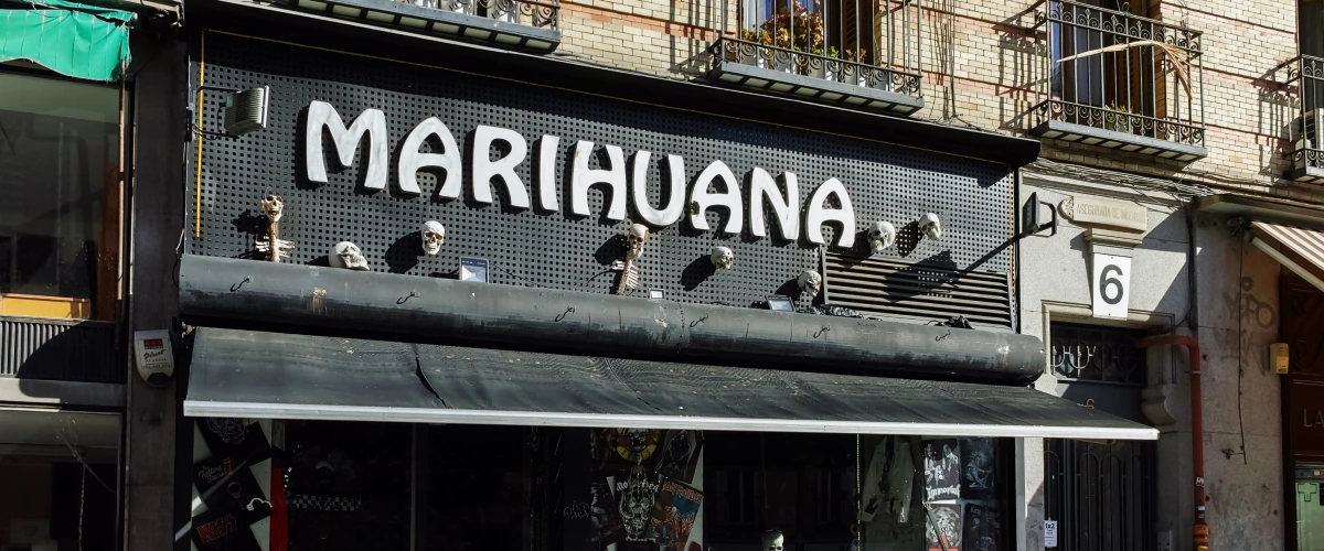 Voorgevel van een cannabis social club in Spanje met een groot marihuana-bord boven de ingang.