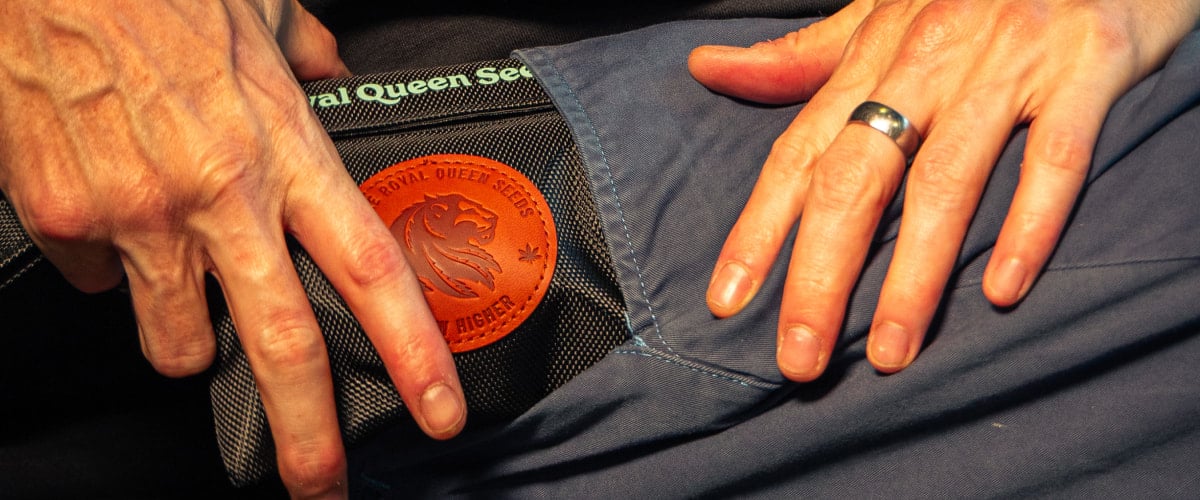 Afbeelding van handen die een geurvrije cannabis opbergtas in een zak stoppen.