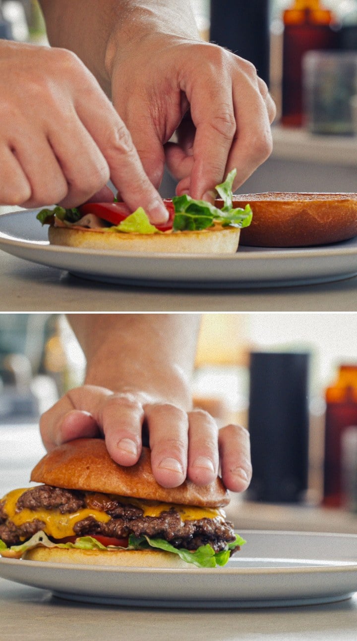 Cannabisburger Klaar om te Serveren – Geïnfuseerd Broodje en Cheddar Samenstellen en serveren van een afgewerkte cannabisburger met gesmolten cheddar, sla, tomaat en een geïnfuseerd broodje