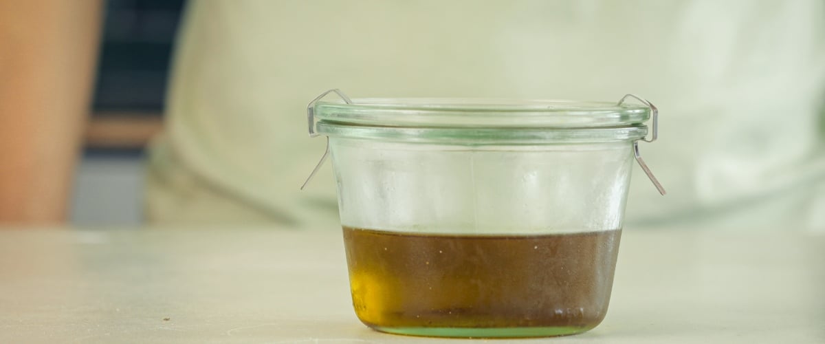 Cannabis-geïnfuseerde MCT-olie in een luchtdichte amberkleurige glazen fles gieten voor opslag, laatste stap van het infusieproces