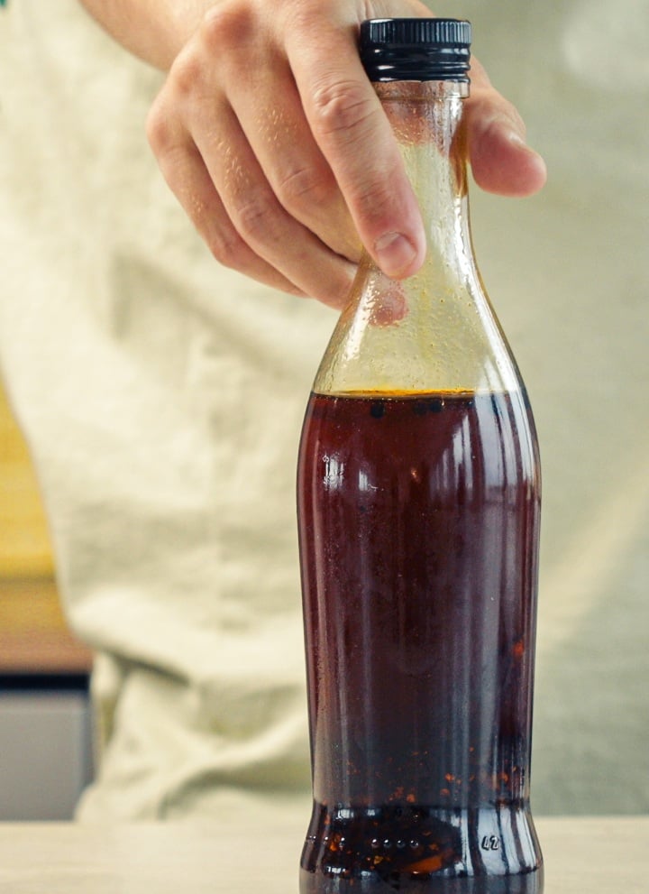 Stap 4: Chili-Cannabisolie Correct Bewaren Afgesloten glazen fles gevuld met chili-cannabisolie opgeslagen in een keuken