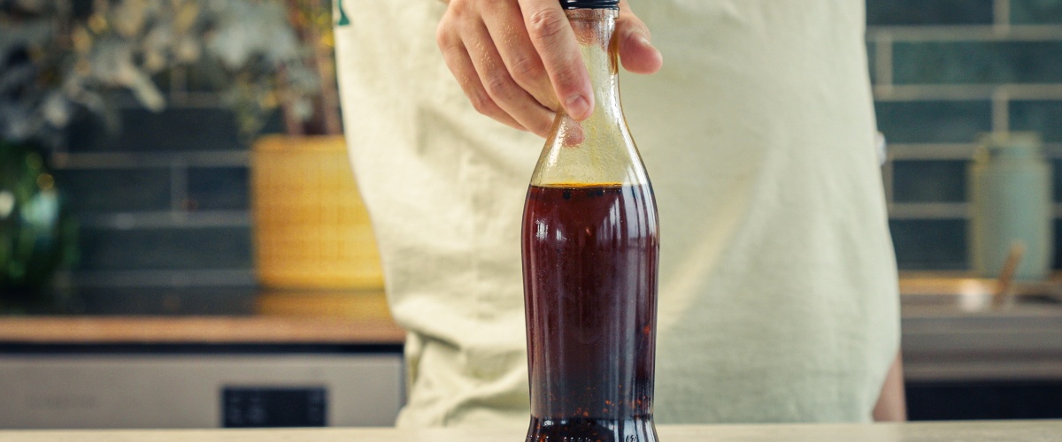 Stap 4: Chili-Cannabisolie Correct Bewaren Afgesloten glazen fles gevuld met chili-cannabisolie opgeslagen in een keuken